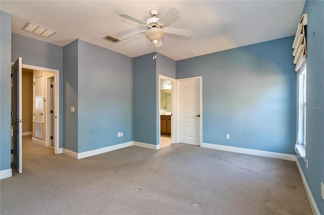 unfurnished bedroom featuring light carpet, ensuite bathroom, and ceiling fan