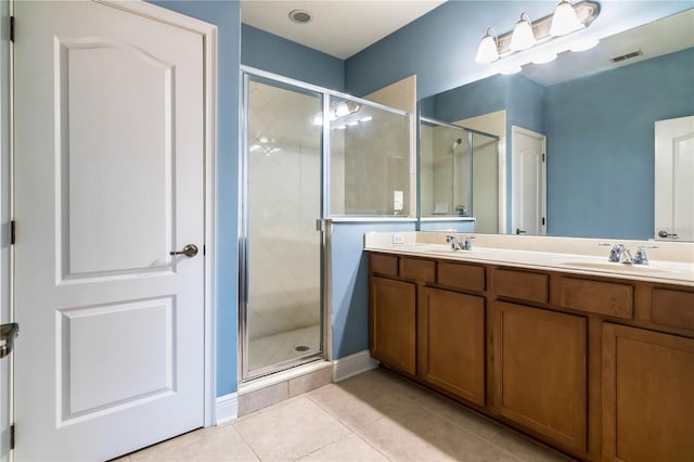 bathroom with tile patterned flooring, vanity, and walk in shower