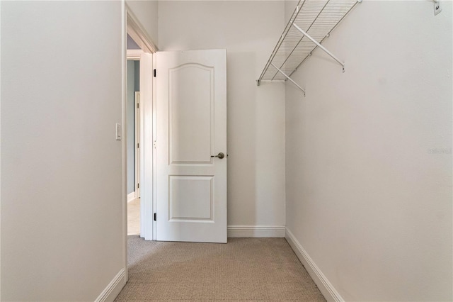 walk in closet featuring light carpet