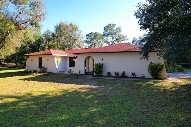 mediterranean / spanish home featuring a front lawn