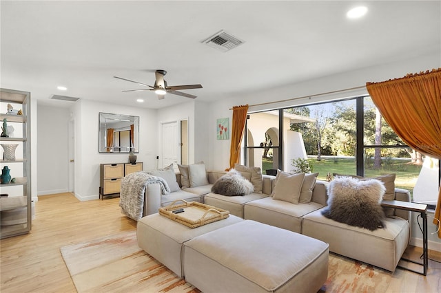 living room featuring ceiling fan and light hardwood / wood-style flooring