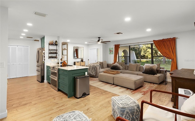 living room with ceiling fan and light hardwood / wood-style floors