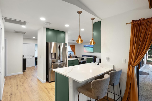 kitchen with kitchen peninsula, stainless steel appliances, decorative light fixtures, light hardwood / wood-style floors, and a kitchen breakfast bar