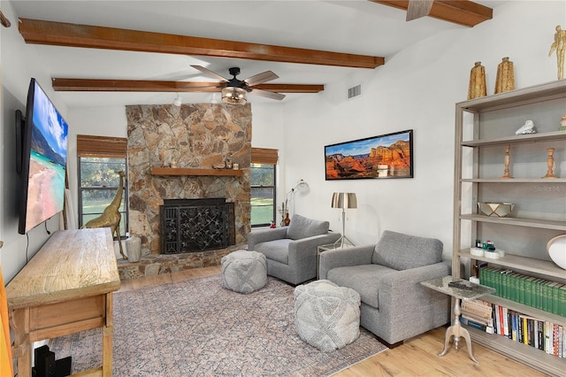 living room featuring a fireplace, hardwood / wood-style flooring, ceiling fan, and beam ceiling