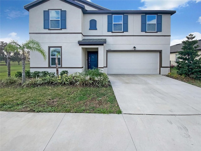 traditional-style home with driveway, a garage, and stucco siding