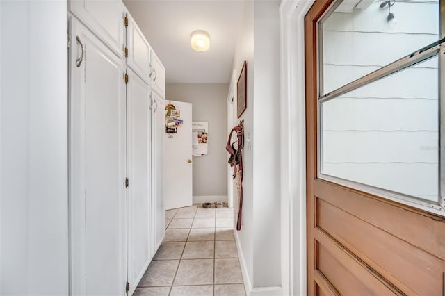 hall with baseboards and light tile patterned flooring