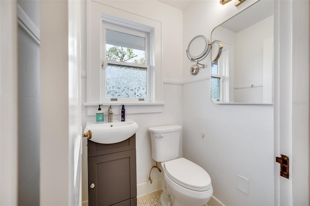 bathroom featuring toilet, vanity, and baseboards