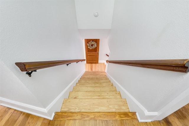 stairway with baseboards and wood finished floors