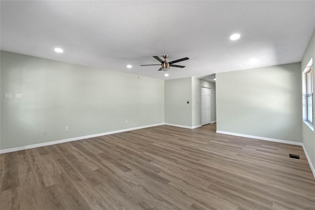 unfurnished room featuring recessed lighting, visible vents, a ceiling fan, wood finished floors, and baseboards