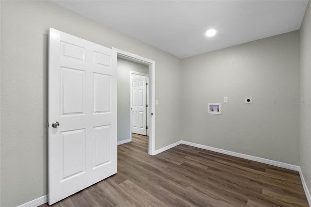 clothes washing area with dark wood-style flooring, hookup for a washing machine, hookup for an electric dryer, laundry area, and baseboards