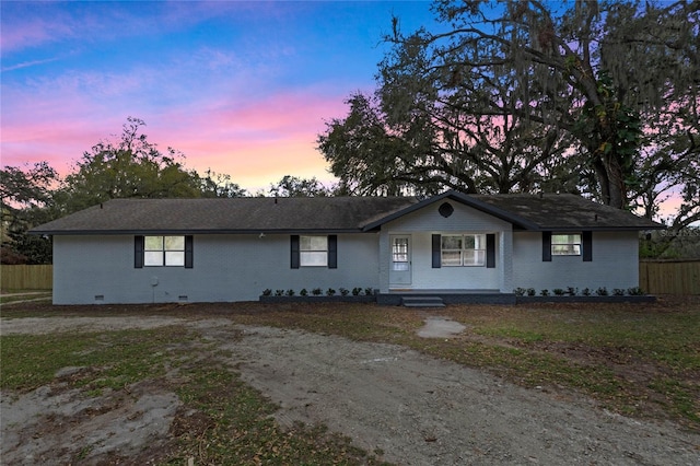 ranch-style home featuring crawl space, brick siding, fence, and covered porch