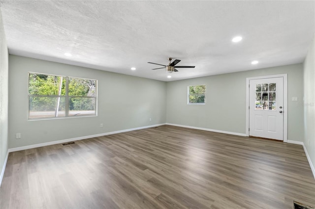 unfurnished living room featuring recessed lighting, ceiling fan, a textured ceiling, wood finished floors, and baseboards