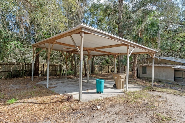 view of patio featuring fence and a carport