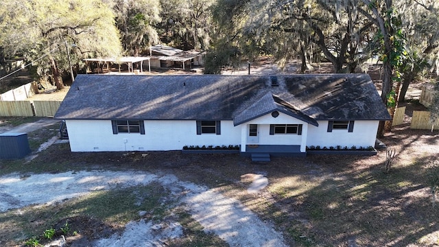 view of front of house featuring a shingled roof and fence