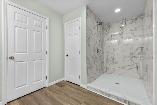 full bathroom featuring a stall shower, wood finished floors, and baseboards