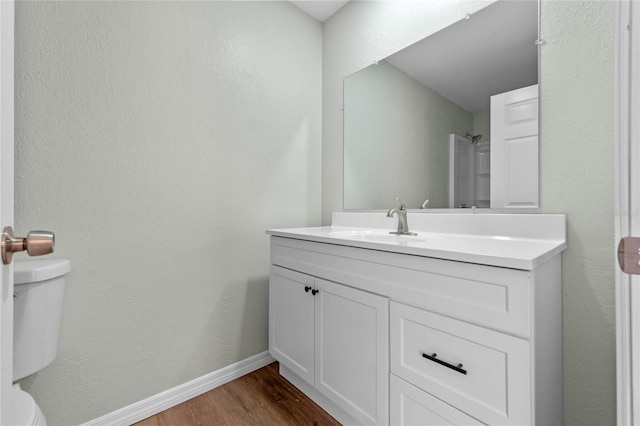 full bathroom featuring baseboards, vanity, toilet, and wood finished floors