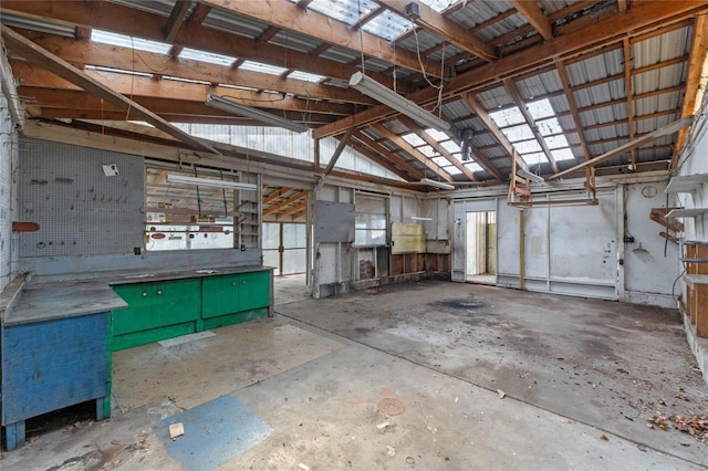 miscellaneous room with vaulted ceiling, metal wall, and concrete flooring