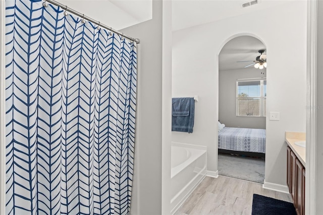 bathroom featuring hardwood / wood-style flooring, ceiling fan, vanity, and curtained shower