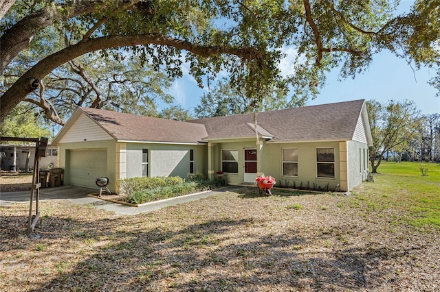 ranch-style house with an attached garage, roof with shingles, and stucco siding