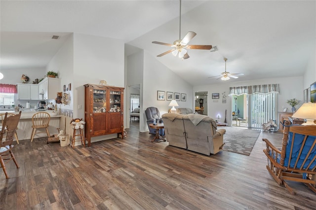 living area featuring high vaulted ceiling, visible vents, dark wood-style flooring, and a wealth of natural light