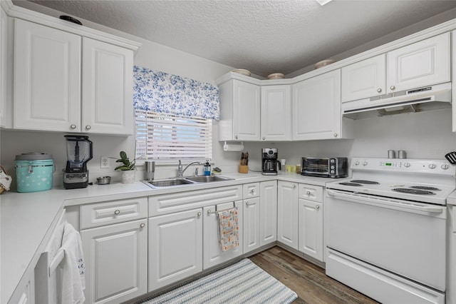 kitchen with white cabinets, under cabinet range hood, electric range, and light countertops