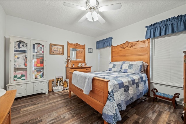 bedroom featuring dark wood finished floors, a textured ceiling, and ceiling fan