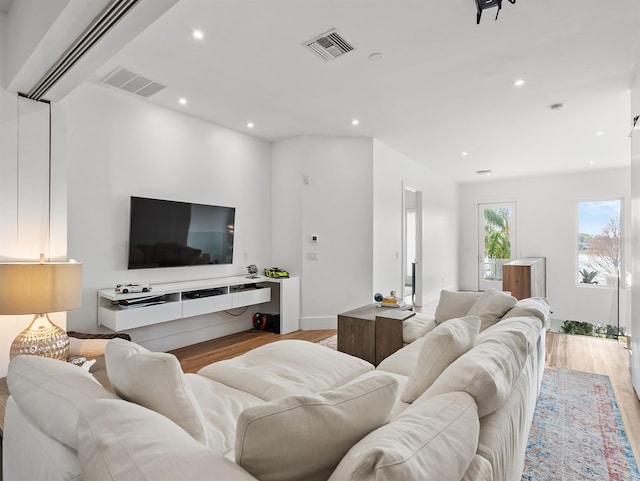 living room with light wood-style floors, visible vents, and recessed lighting