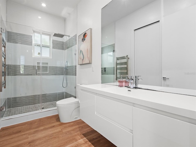 full bathroom with radiator, toilet, wood finished floors, vanity, and a shower stall