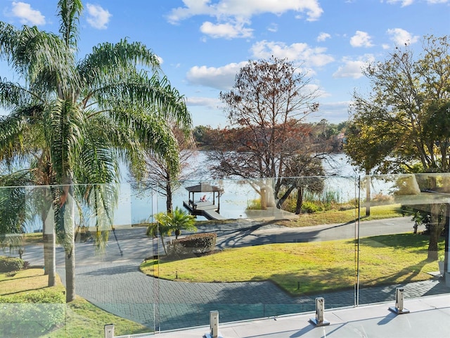 view of property's community featuring a lawn and fence