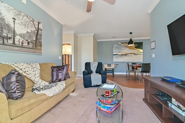 living room featuring baseboards, ornamental molding, and a ceiling fan