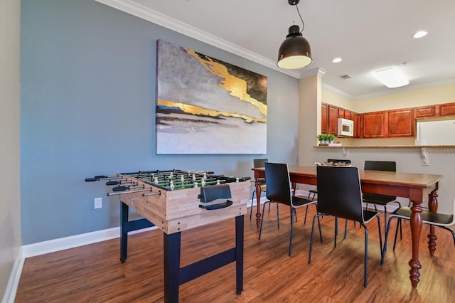 dining space with recessed lighting, baseboards, crown molding, and wood finished floors