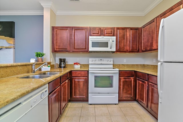 kitchen featuring reddish brown cabinets, white appliances, light tile patterned floors, and a sink