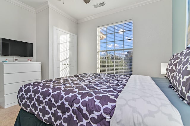 carpeted bedroom featuring ceiling fan, visible vents, and crown molding