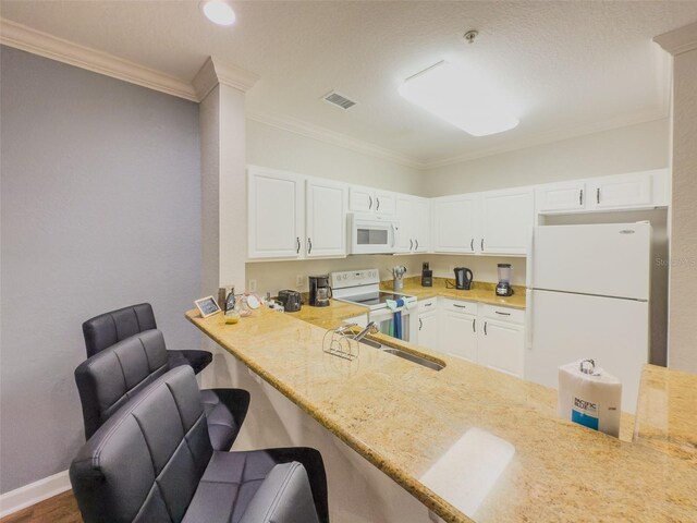 8000 Tuscany Way Unit 4405, Davenport, FL 33896 - kitchen featuring white appliances, crown molding, white cabinetry, a kitchen bar, and a peninsula