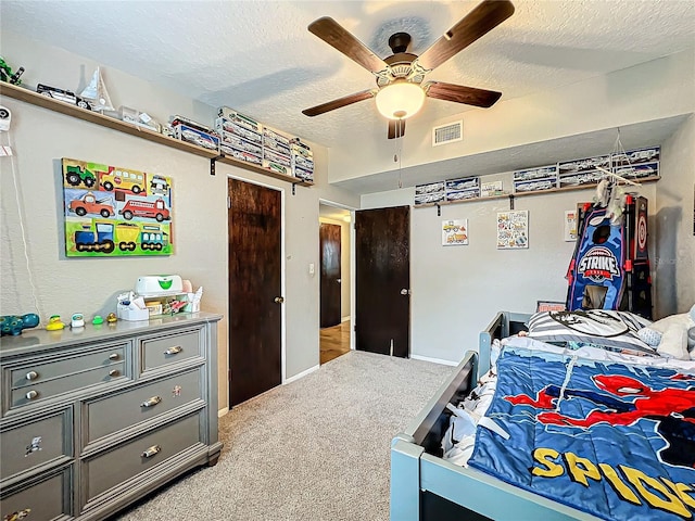 carpeted bedroom with a textured ceiling and ceiling fan