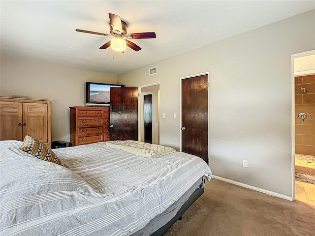 carpeted bedroom with ceiling fan and ensuite bath