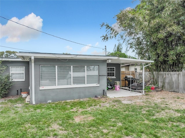 back of property featuring a patio and a lawn