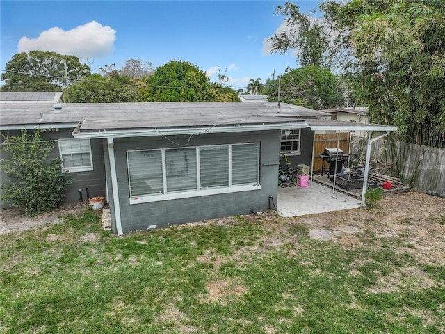 rear view of property with a lawn and a patio