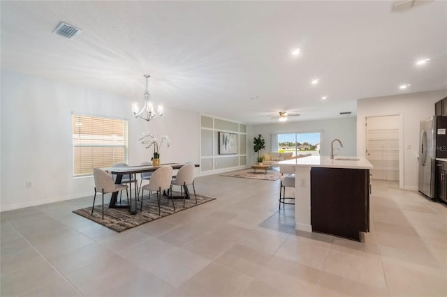 dining area with light tile patterned floors, recessed lighting, baseboards, visible vents, and ceiling fan with notable chandelier