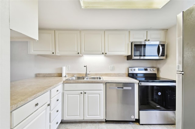 kitchen with appliances with stainless steel finishes, sink, and white cabinetry