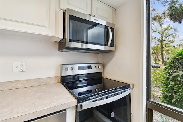 kitchen featuring stainless steel appliances and white cabinets