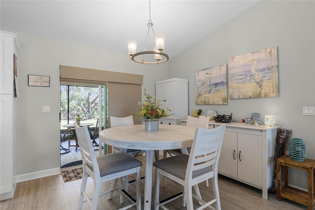 dining room with a chandelier, vaulted ceiling, light wood-style flooring, and baseboards