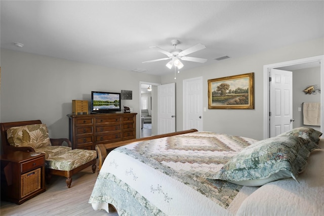 bedroom with light wood finished floors, visible vents, and a ceiling fan