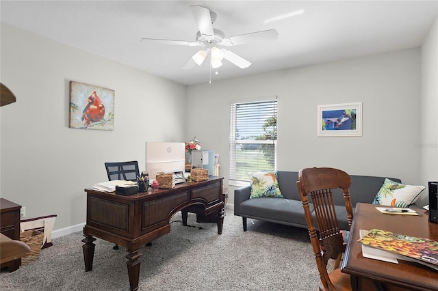 carpeted office space with ceiling fan and baseboards