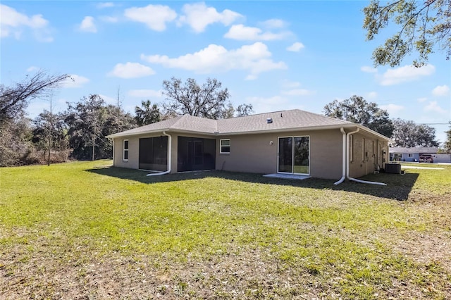 rear view of property featuring a sunroom, a yard, and central AC unit