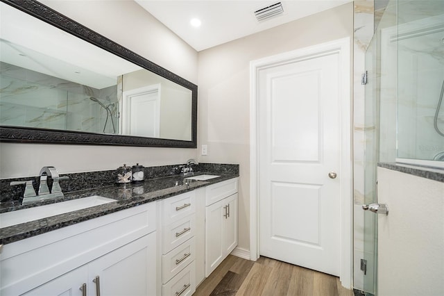 bathroom with hardwood / wood-style floors, an enclosed shower, and vanity