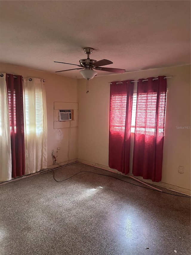 unfurnished room with a textured ceiling, ceiling fan, and a wall unit AC