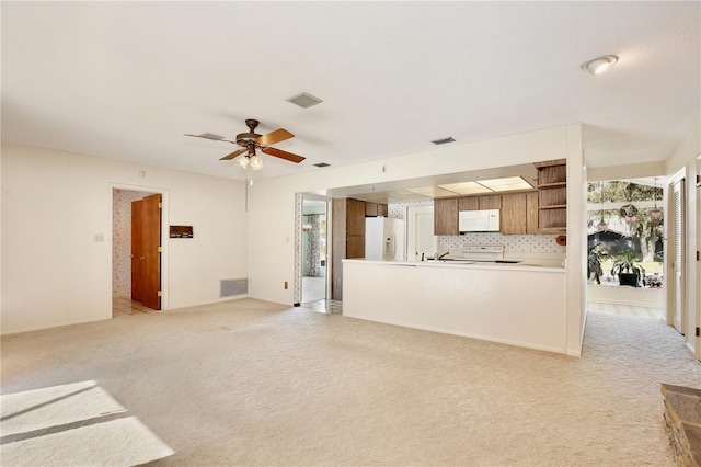 unfurnished living room with ceiling fan and light colored carpet