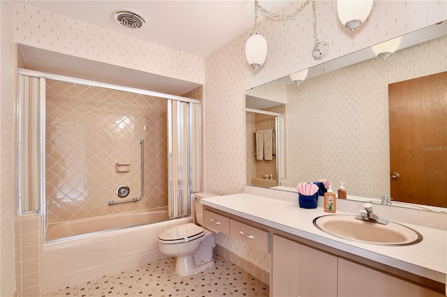 full bathroom with tile patterned floors, vanity, combined bath / shower with glass door, and toilet