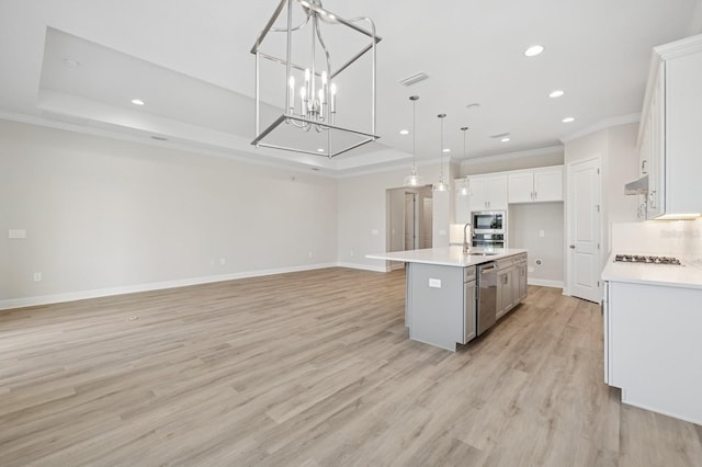 kitchen with stainless steel appliances, recessed lighting, crown molding, open floor plan, and white cabinets